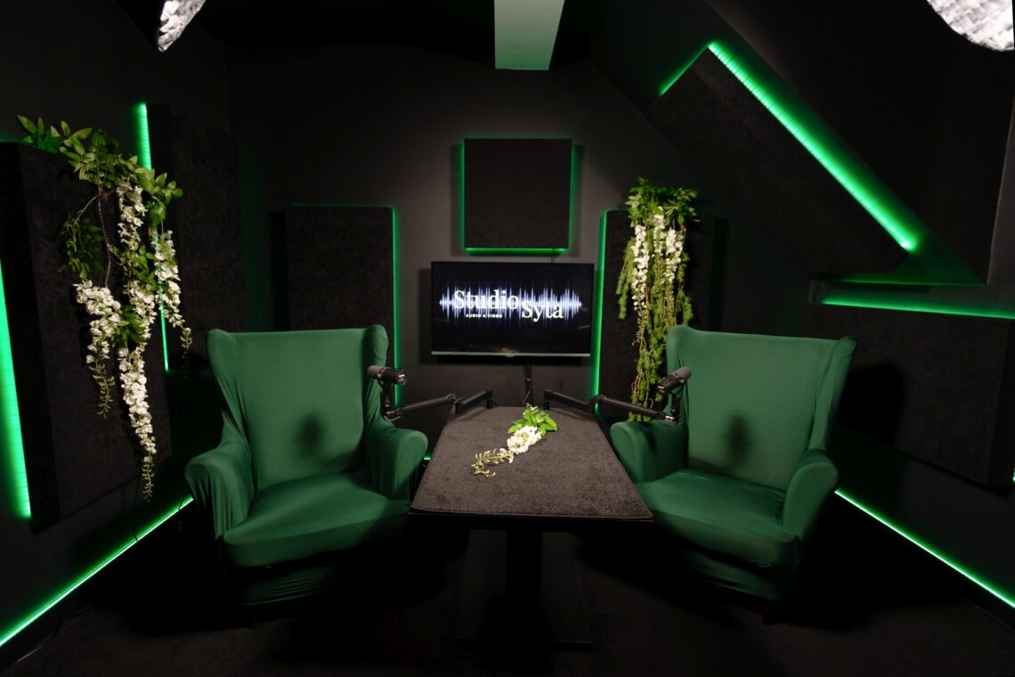 Studio Syta z zielonymi fotelami i kwiatami