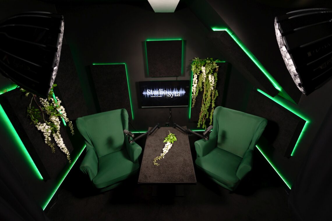 Studio w Warszawie do nagrań podcastowych, zielone fotely, zielone oświetlenie